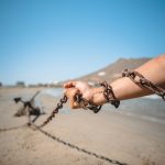 a person holding a chain on a beach