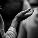A black and white photo of a person holding their hands together