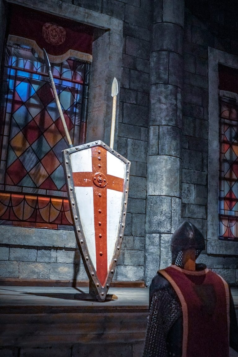 A knight standing in front of a shield and sword