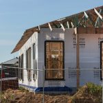 a house under construction with a fence around it