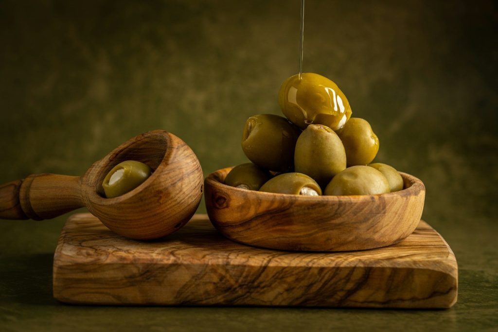a wooden spoon with a group of potatoes on it