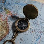 round brass-colored compass on map