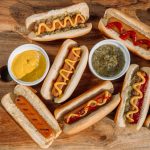 hotdog sandwich with sauce on brown wooden table